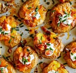 Crispy loaded smashed potatoes topped with cheddar cheese, bacon, sour cream, and chives